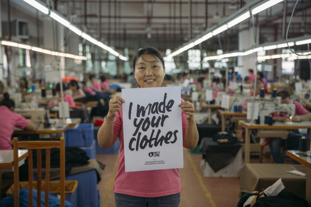 A Picture Organic garment worker holding a sign that says I made your clothes