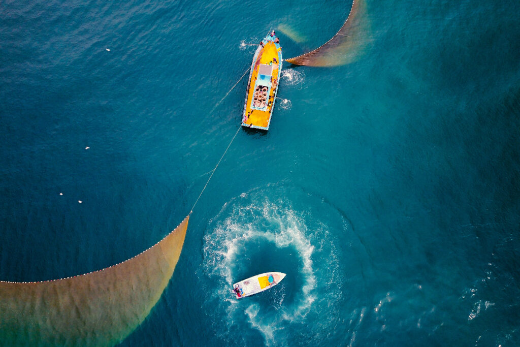 Fishing boat out at sea with trawler nets