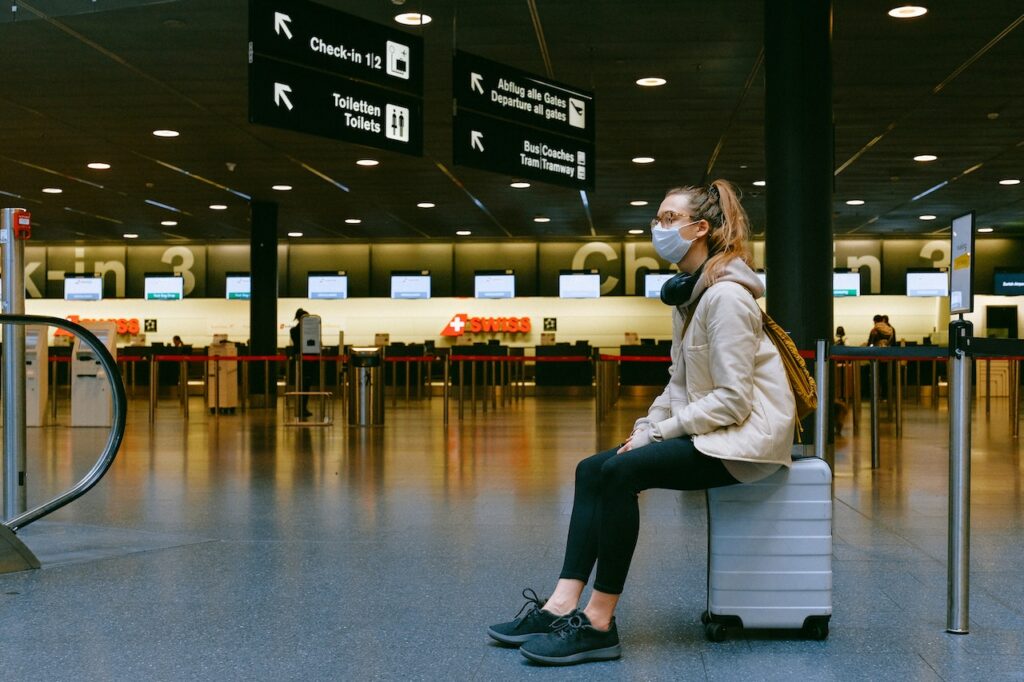 Girl in Airport sitting on suitcase